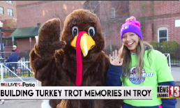 Trotter, the Troy Turkey Trot Mascot with caption "Building Turkey Trot Memories In Troy"